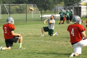 Coach Mike Muehling throwing with the quarterbacks. [photo by: Matt Whalen]