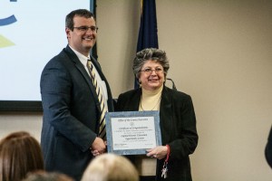 Christopher Meyer, Rensselaer County Deputy Director presents Dr. Lucille Marion with a certificate of congratulations.
